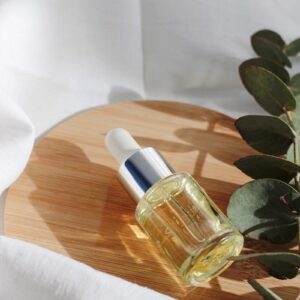 clear glass bottle on white textile